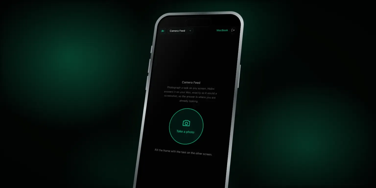 A tilted iPhone against a dark green background, showing the Hidini phone remote in Camera Feed mode: the mode picker reads Camera Feed, the paired Mac is MacBook, and a large round Take a photo button sits under a short explanation, with the hint Fill the frame with the task on the other screen.